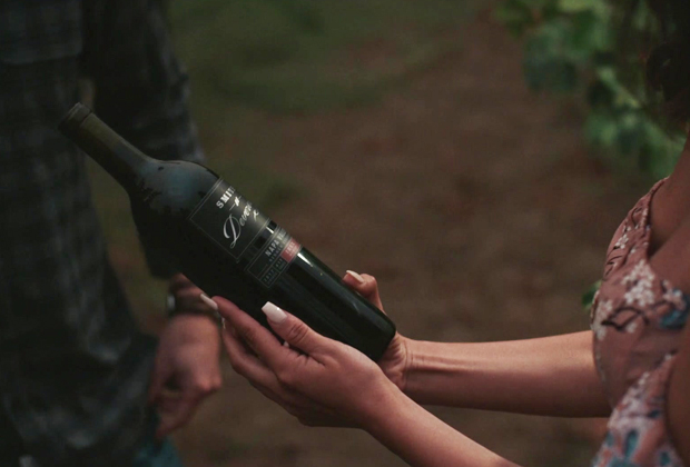 Smith Devereux Vineyard Tour Promotion A woman holding a Smith Devereux wine bottle.