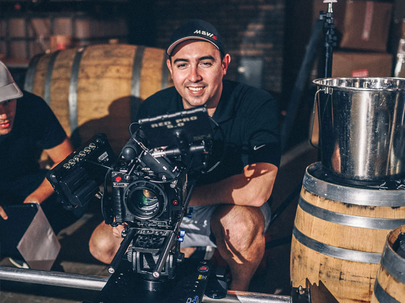 Smith Devereux Pour video expert Pour video expert operates a RED cinema camera on a rig in a winery setting.