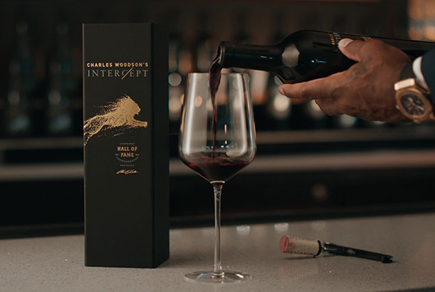 Charles Woodson pours Intercept Wines into a glass.